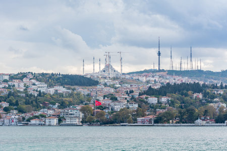 Cityscape of Bosphorus strait with Camlica Mosque and ancient and modern buildings in Istanbul Turkey from ferry on a sunny day with background cloudy skyの写真素材
