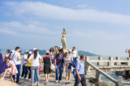 A lot of visitors standing and taking picture in front of the landmark of Zhuhai city of China. Statue of Fish Womanのeditorial素材