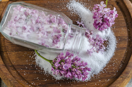 Lilac flowers and sugar on a wooden board. From the series Cooking lilac syrupの写真素材