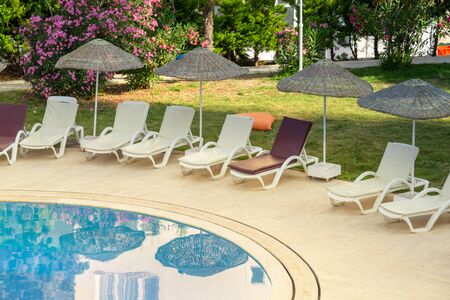 Pool with sunbeds and umbrellas is near the sea.Concept of tourismの写真素材