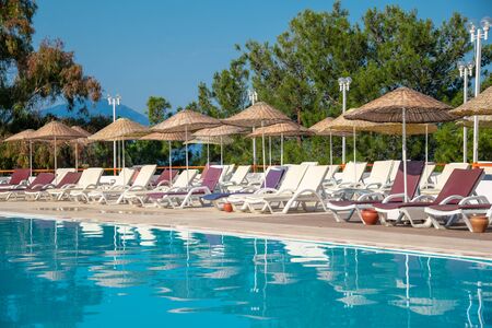 Pool with sunbeds and umbrellas is near the sea.Concept of tourismの写真素材