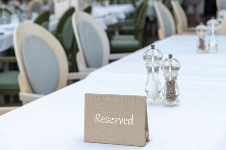 Elegant table setting with RESERVED sign on white background. Space for text. Horisontal background. Close-up.の写真素材