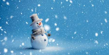 Banner with white snowman closeup on blue background, top view. Merry Christmas and Happy New Year holiday concept.の素材