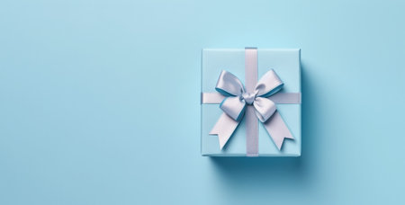 Banner with blue gift box with ribbon and bow for man and boy isolated on blue background.Holiday gift with Birthday or Christmas present,flat lay,top view,father's day,copy space.Generated by AI.の素材