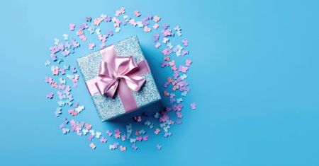 Banner with blue gift box with ribbon and bow isolated on blue background.Holiday gift with Birthday or Christmas present,flat lay,top view,copy space.Generated by AI.の素材