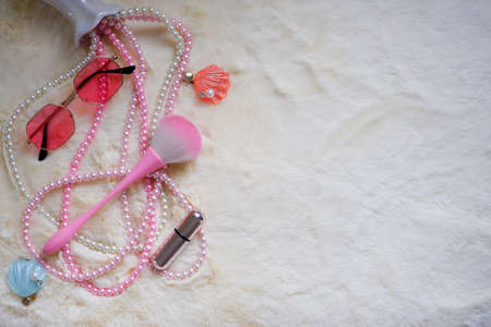Flat lay women's accessories and glasses desk.Shells and pearl necklace on blue pale pink background. top view.Copy spaceの写真素材