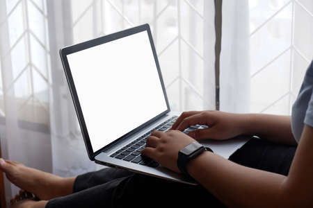 Woman holds tablet in hands. Morning online activities in home. Relax in sofa, watching movies and TV shows on mobile device. Social media addiction. Work at home, freelance. Technology in lifestyleの写真素材