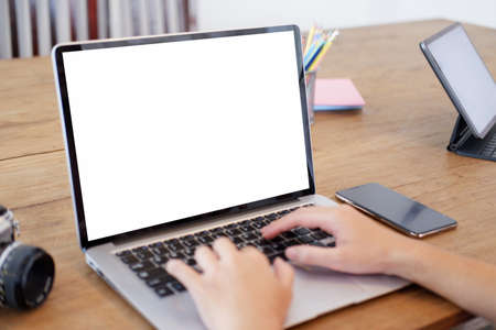Young woman using black tablet device with white screen. Woman holding tablet, scrolling pages while sitting on the sofa in the living room.の写真素材