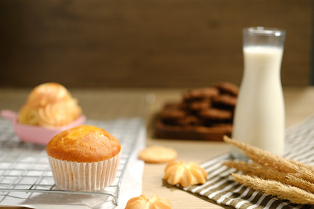homemade muffins in white paper muffin cups and a glass of milk on the table..の写真素材