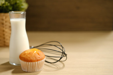 homemade muffins in white paper muffin cups and a glass of milk on the table..の写真素材