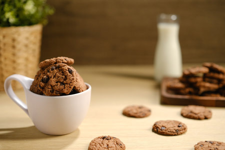 Homemade Chocolate Chip Cookies above Wooden Table, Served with a Bottle of Milk. Bakery Concept with Copy Space for Text.の写真素材