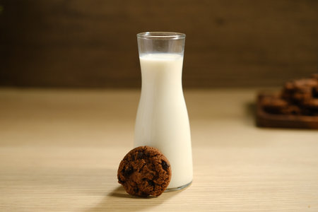 Homemade Chocolate Chip Cookies above Wooden Table, Served with a Bottle of Milk. Bakery Concept with Copy Space for Text.の写真素材