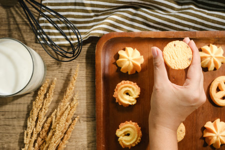 Crop woman taking cookies from wood tray.の写真素材