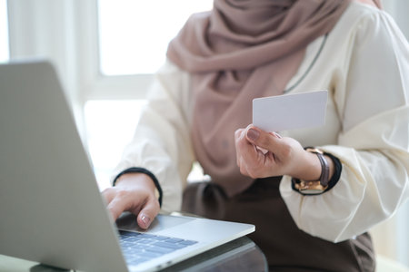 Young woman holding credit card and using laptop computer. Online shopping concept.の写真素材
