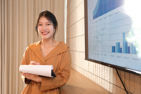 Image of young asian woman, company worker smiling and holding documents.の写真素材