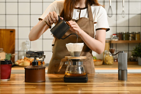 A woman is making coffee and pouring it into a cup. The scene is set in a kitchen with various items...