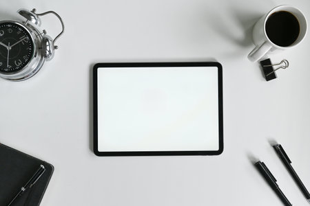 Minimalist white office desk with tablet, coffee and stationery..の写真素材