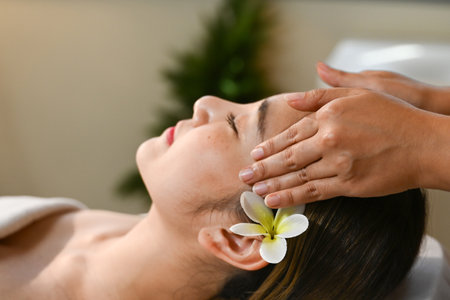 Beautiful Asian woman getting a face massage at the spa.の写真素材