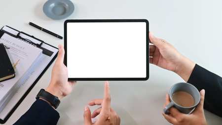 Close up of business team working analysis brainstorm together tablet blank white screen placed at office. Mock up..の写真素材