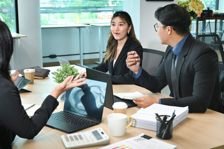 Happy businessman talking to his colleagues on a meeting in the office.