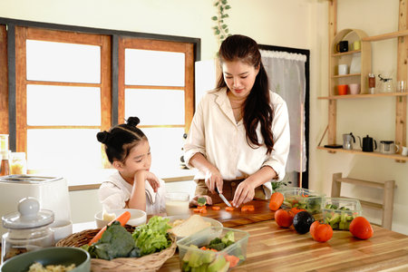 daughter mother kitchen food preparing cooking child bonding happy girl together home parent.の写真素材
