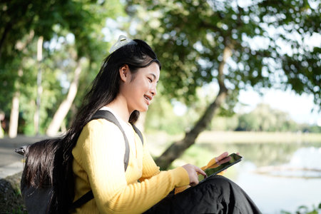 young teenage girl enjoying a quiet afternoon under a tree, with the sun filtering through the...