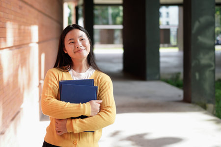 Back to school student teenager girl holding books . Outdoor portrait of young teenager asian girl with long hair. girl on city.の写真素材