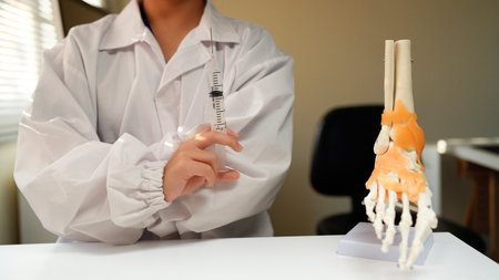 Woman doctor wearing uniform holding syringe in clinic.の写真素材
