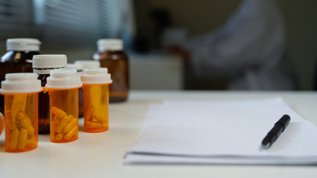 Blank Paper with Pen and A Bottle of medicine pills on Table at office room.
