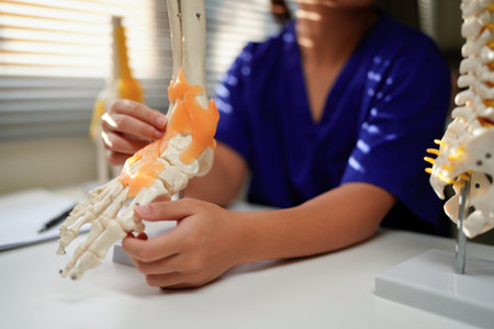 Anatomical foot skeleton model in doctor hands close-up, while consultation in orthopedic clinic....
