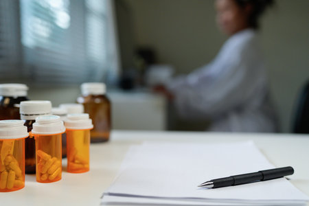 Blank Paper with Pen and A Bottle of medicine pills on Table at office room.の写真素材