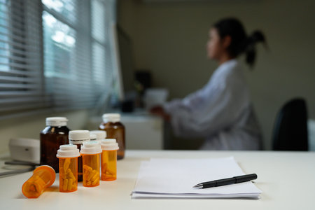 Blank Paper with Pen and A Bottle of medicine pills on Table at office room.の写真素材