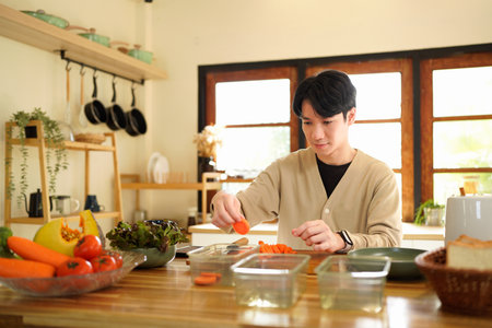 Making a healthy meal from scratch. Shot of a happy young man preparing a healthy snack at home..の写真素材
