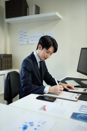 businessman hand working with finances about cost and calculator and computer on desk in modern office.の写真素材