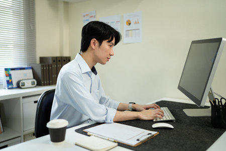 Business man, thinking and computer at desk in office for online research, reading email or report. Male entrepreneur person with internet connection for feedback, review and focus on project.の写真素材