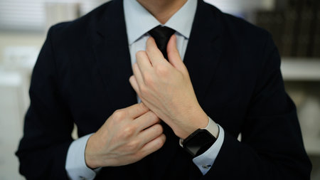 People, business, fashion and clothing concept, close up of man in shirt dressing up and adjusting tie on neck at home..の写真素材