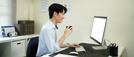 Software developer drinking coffee while working with computer in the modern startup office..の写真素材