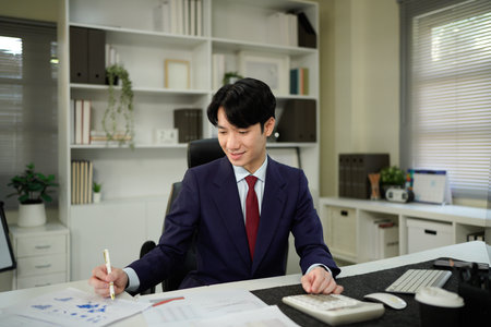 businessman hand working with finances about cost and calculator and computer on desk in modern office.の写真素材