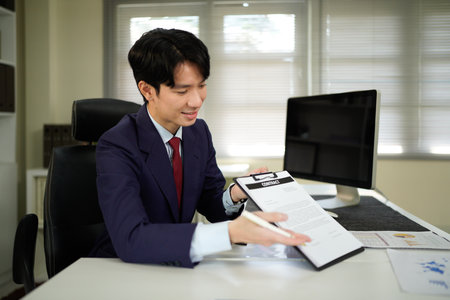 Close up of business man hands showing and pointing contract signature space in office, business deal and sign a contract agreement in the office..の写真素材