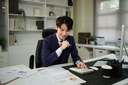 businessman hand working with finances about cost and calculator and computer on desk in modern...