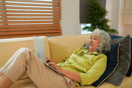 Old woman work at home using notebook computer..の写真素材