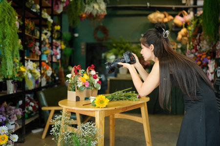 Young asian women owner floral store using digital camera take a photo bouquet sending to client....