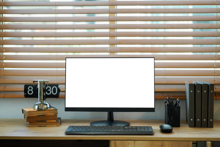 Computer monitor mockup with blank screen on wooden desk in contemporary minimalist home office with...