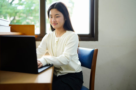 Girl studying with laptop in university class.