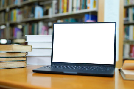 Blur library interior background for your design, desk with books and laptop.