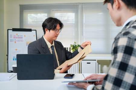 Application, hands and interview with business people in human resources office for hiring or recruitment. CV, documents or resume with manager and candidate talking in office for job opportunity.の写真素材