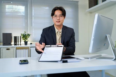 Asian businessman pointing on paper for sign signature contract while explaining and consultation...