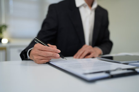 young man in suit writing business papers at desk in modern working office. copy space.の写真素材