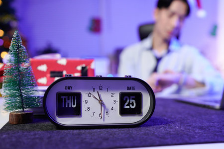 Businessman working late on Christmas day in office.