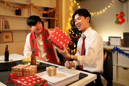 xmas business party, Friends celebrating holiday season in office environment with gift exchange.の写真素材